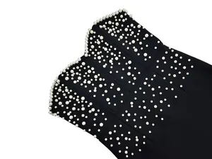 Detailed macro view of an elegant black bandage dress with white pearl embroidery