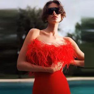 Close-up of elegant red ostrich feather bandage dress with strapless designer detail.