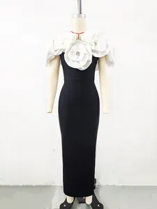 Detail view of large white 3D fabric flowers on an elegant black bandage evening gown.