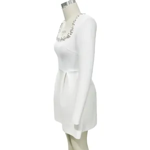 Detailed side view of white long sleeve bandage dress featuring sparkling rhinestone collar