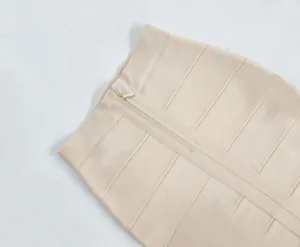 Close-up view of the zipper detail on a beige bandage bodycon skirt with elastic texture.