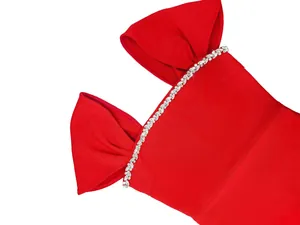 Elegant detail of a red evening dress featuring bow sleeves and sparkling rhinestone trim