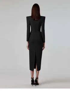 Back view of elegant black long sleeve midi dress with padded shoulders and slit