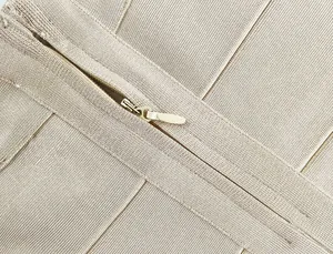 Close-up detail showing high-quality concealed zipper on elastic champagne bandage skirt