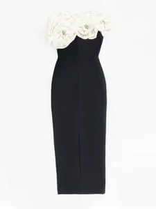 Close-up of elegant black bandage dress with oversized 3D white fabric flower decorations