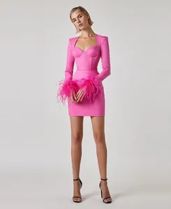 Detailed view of the elegant pink square neck bandage dress with ostrich feather cuffs.