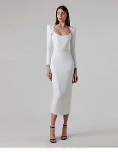 Elegant white square neck midi dress with structured horn shoulders and long sleeves.