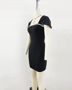 Side view of an elegant black bandage dress with rhinestone details on mannequin.