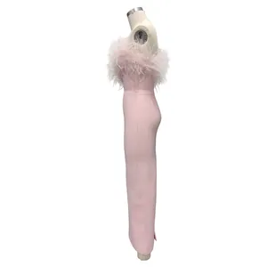 Side view of an elegant pink bandage gown with ostrich feather trim on a mannequin for evening.