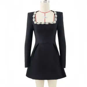 Detailed view of square neckline with elegant floral rhinestone appliques on black dress