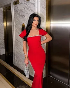Close-up of elegant red evening gown featuring exquisite crystal neckline embellishment detail