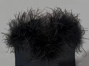 Close-up detail of luxurious black ostrich feather trim on a bandage evening gown.