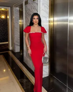 Full length view of an elegant red bandage dress featuring a sparkling rhinestone trim.
