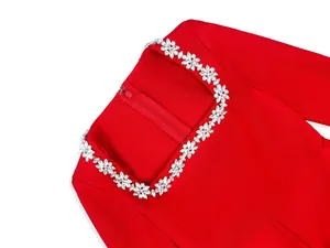 Close-up of red square neck jumpsuit with sparkling rhinestone flower trim details.