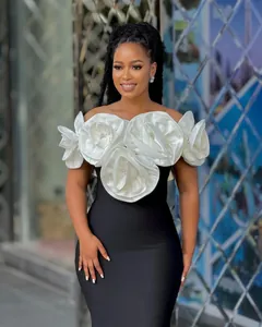 Elegant high-end black and white evening gown with large white floral shoulder details