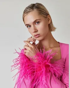 Detail view of vibrant pink ostrich feather trim on a square neck bandage dress