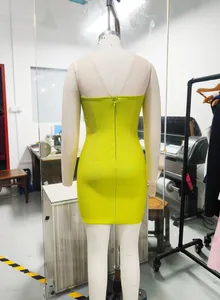 Back view of a lime green bandage bodycon party dress with mesh detail on mannequin.