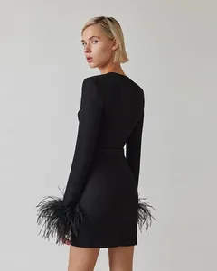 Detail view of black bandage dress showing elegant ostrich feather cuffs and back fit