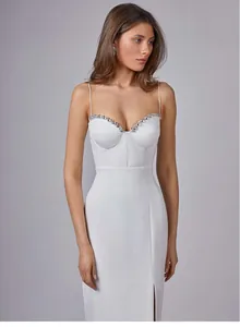 Detailed view of white spaghetti strap bandage dress with rhinestone bust and side slit