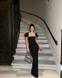 Elegant black bandage evening gown with sparkling rhinestone trim shown on a model