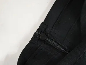 Detailed macro view of the hidden back zipper and hook closure on black bandage skirt