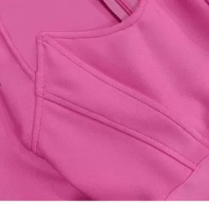 Close-up detail of a pink bandage dress with square neckline and horn shoulder structure