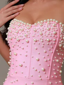 Close-up of pink bandage dress with elegant pearl embellishments and sweetheart neckline