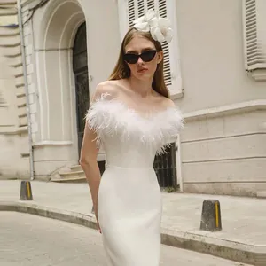 Elegant white off-the-shoulder evening gown with lush ostrich feather trim details.