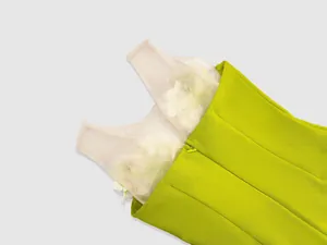 Close-up detail of lime green bandage dress with 3D floral mesh and hidden zipper