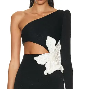 Detailed macro shot of black one-shoulder dress with a large white beaded flower detail