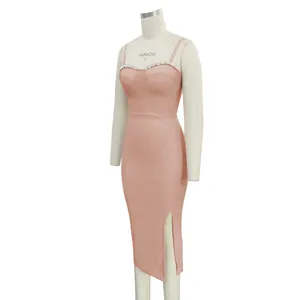 Side view detail of a peach pink bandage dress featuring rhinestone trim and a leg slit
