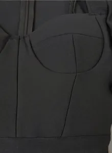 Close-up detail of a black bandage dress bustier showing ribbed texture and seams