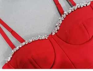 Macro view of luxurious crystal rhinestones on the neckline of a red bandage dress