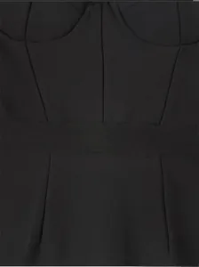 Close-up detail of black ribbed fabric and structured seams on a classic bandage dress