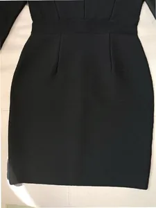 Close-up of the premium knit texture on the waist of a black long-sleeved bandage dress