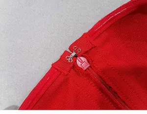 Detailed macro view of the invisible zipper and metal hook closure on a red bandage dress