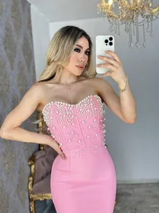 Elegant pink strapless mermaid bandage dress with pearl embellishments for evening