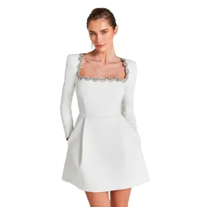 Elegant white long-sleeve mini dress with crystal-embellished square neckline.