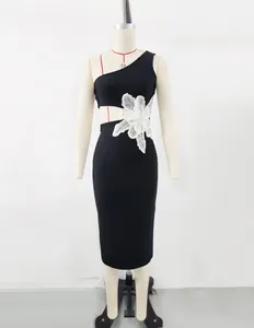 Close-up of black one-shoulder bandage dress featuring a large white flower applique at the waist.