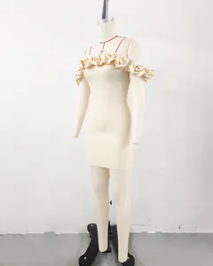 Detailed view of a cream off-the-shoulder bandage dress with 3D floral accents on a mannequin.