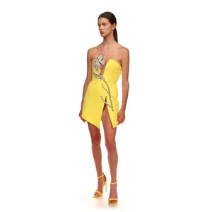 Elegant yellow strapless mini dress featuring a rhinestone flower and thigh slit