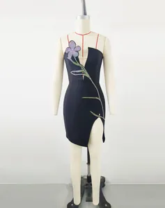 Detailed view of a strapless black dress with floral rhinestone patterns and a side slit.