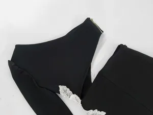 Close-up of black one-shoulder bandage dress featuring white lace and waist cutout detail