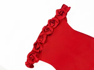 Detailed macro shot of red 3D satin rose flowers on a chic off-the-shoulder bandage dress