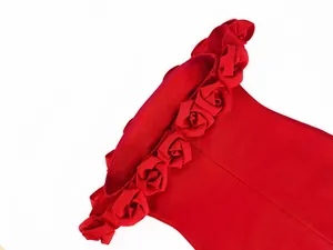 Close-up detail of handmade 3D floral neckline on a luxury red off-shoulder bandage dress