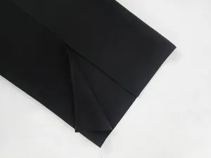 Detailed macro view of the precise side slit and stitching on a black bandage dress.