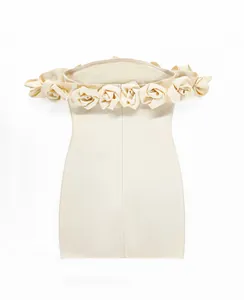 Close-up detail of a cream off-the-shoulder bandage dress featuring 3D floral accents.