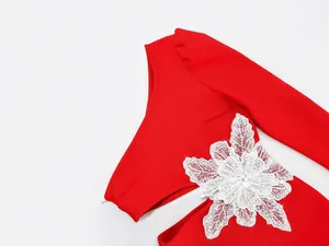 Detailed macro view of elegant red one-shoulder dress with intricate white lace flower detail