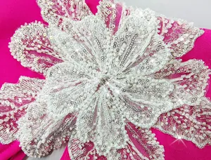 Close-up of intricate white sequined and beaded flower detail on hot pink bandage dress