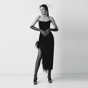 Elegante zwarte strapless avondjurk met struisvogelveren en accessoires van mesh